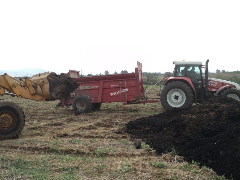 Loading and spreading dewatered sludge on farmland